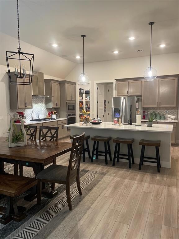 Dining area featuring light hardwood / wood-style flooring and vaulted ceiling