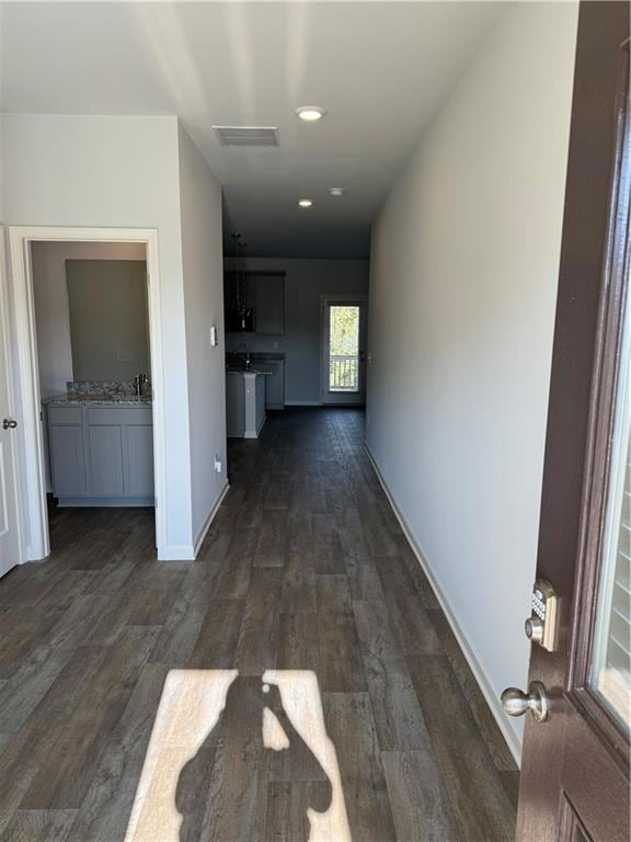 Hallway with dark hardwood / wood-style flooring