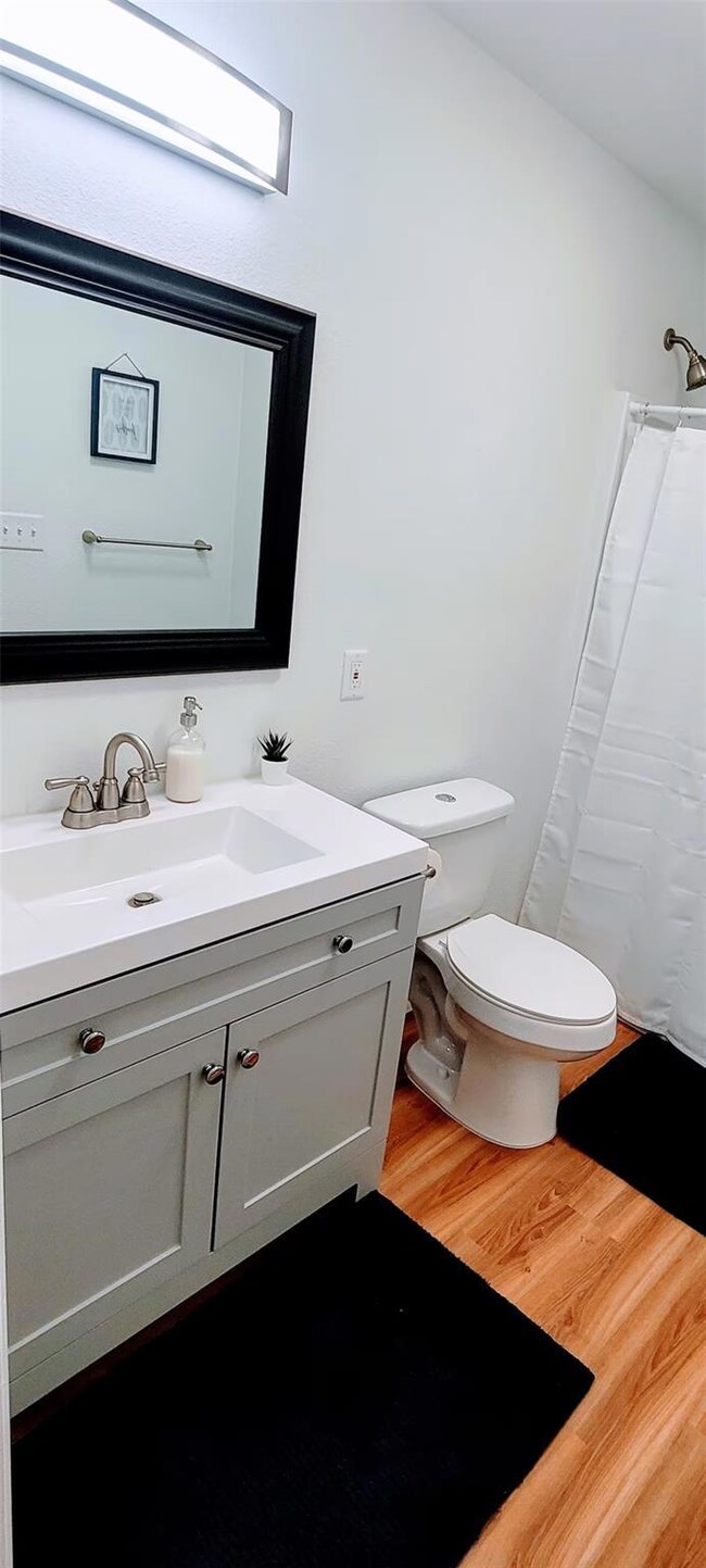Full bathroom with vanity, wood finished floors, 
