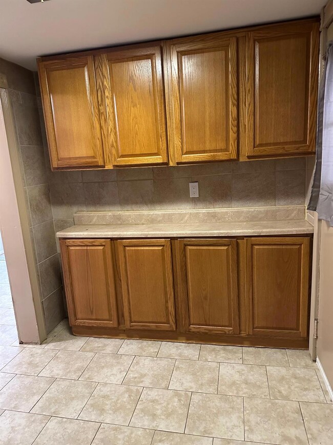 Kitchen featuring brown cabinetry and light countertops