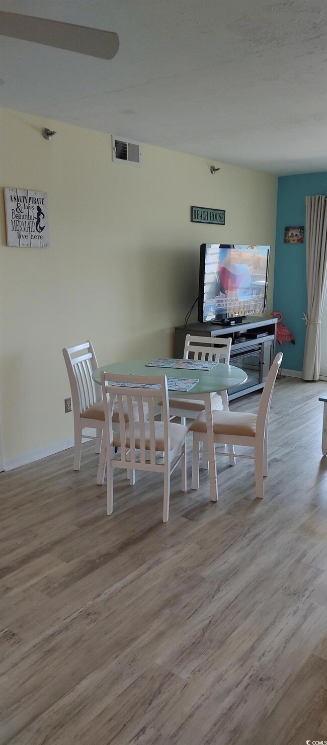 Dining space with wood finished floors and baseboa
