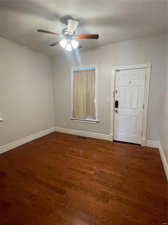 Entrance foyer with a textured ceiling, dark hardwood / wood-style flooring, and ceiling fan