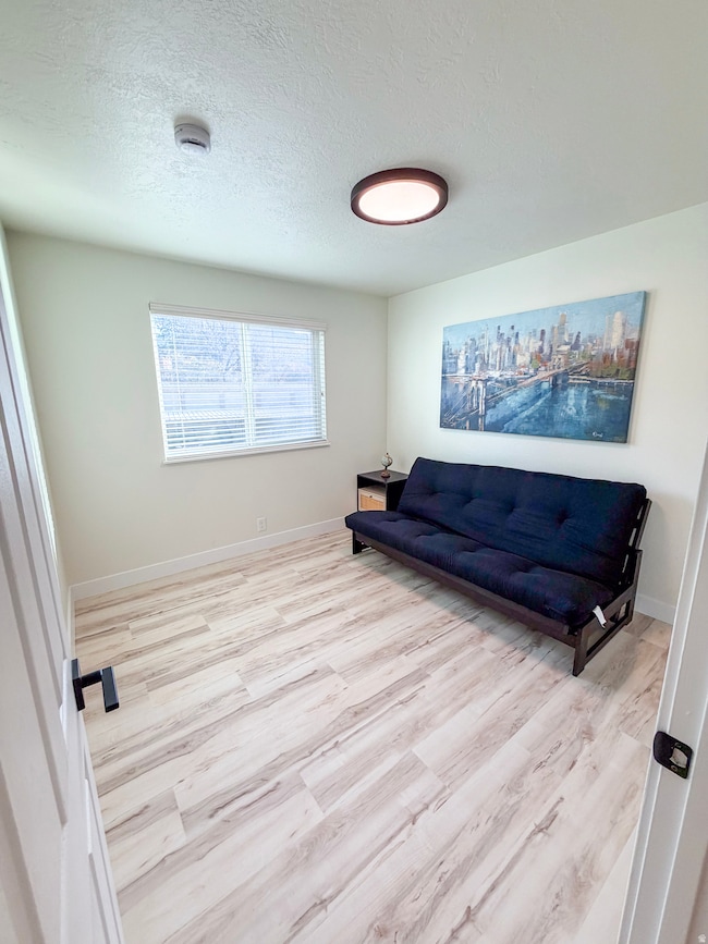Sitting room with a textured ceiling and light wood-type flooring