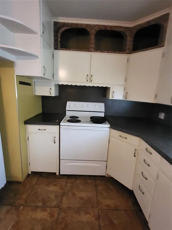Kitchen featuring dark tile flooring, white electr