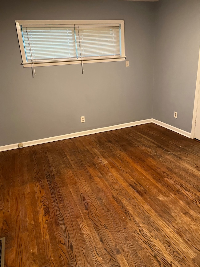 Unfurnished room with dark wood-style floors