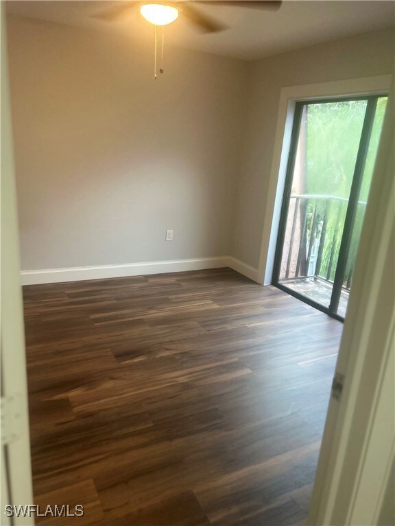 Spare room featuring ceiling fan and dark wood-typ
