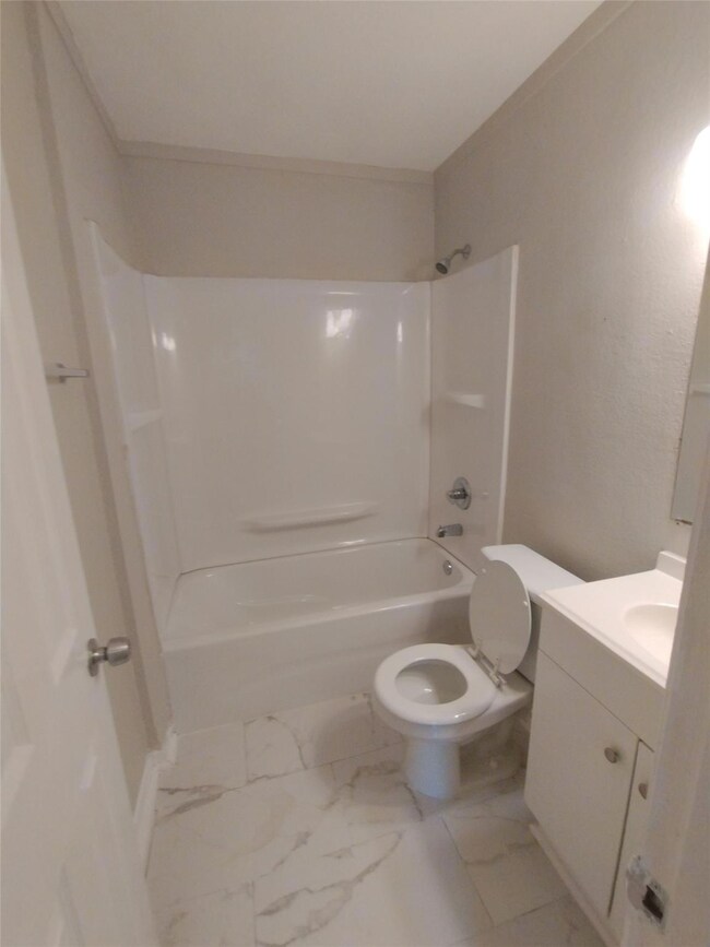 Bathroom featuring toilet, marble finish floor, w