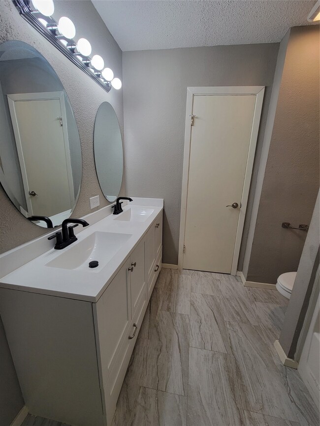 Shared bathroom with double sink and shower/tub co