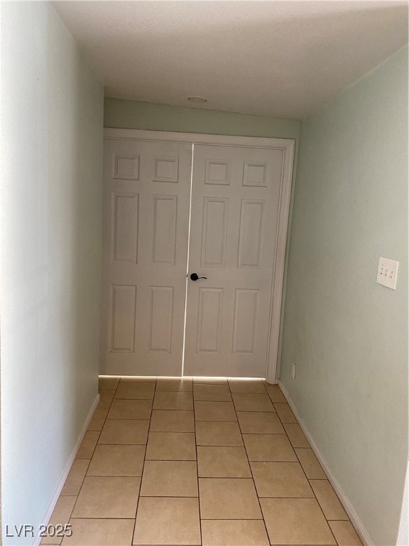 Corridor featuring light tile patterned floors and