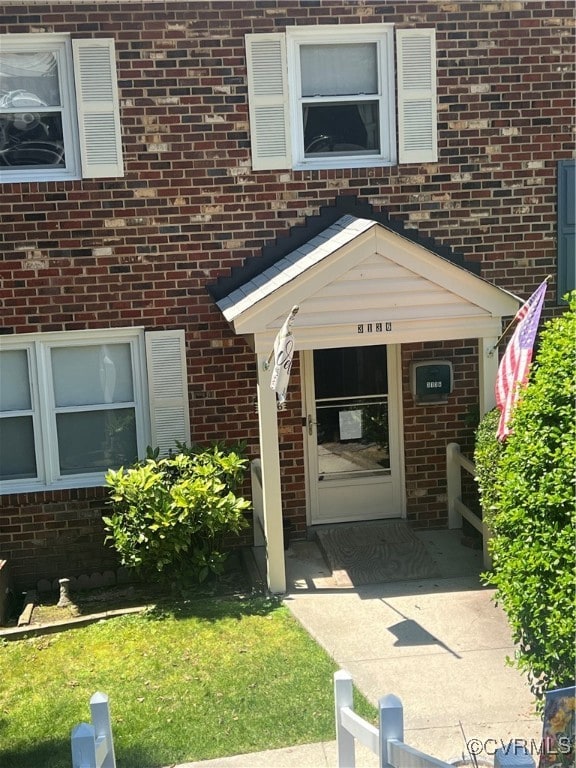 View of exterior entry with brick siding