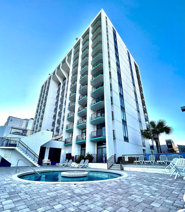 View of building exterior with a community pool