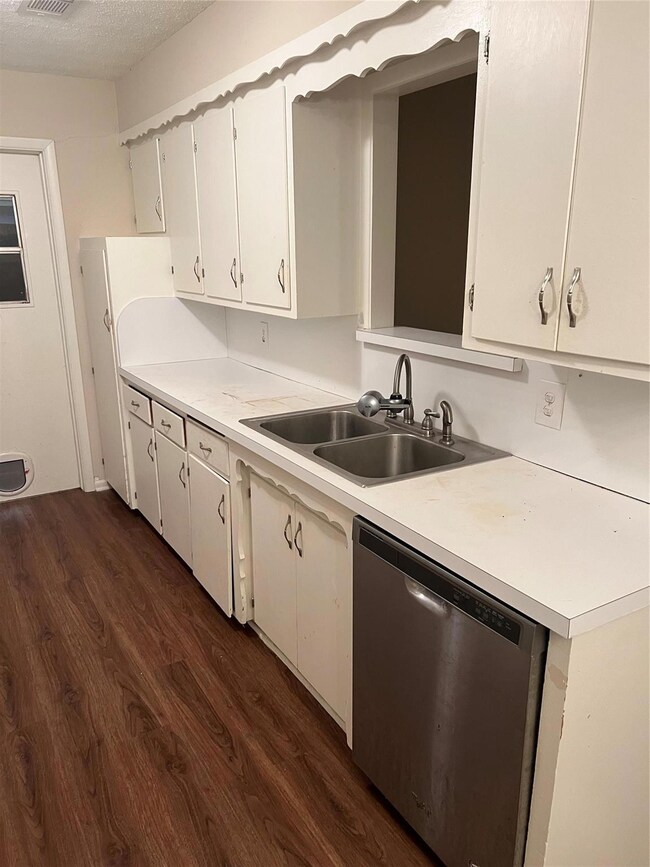 Kitchen featuring dishwasher, sink, dark hardwood 