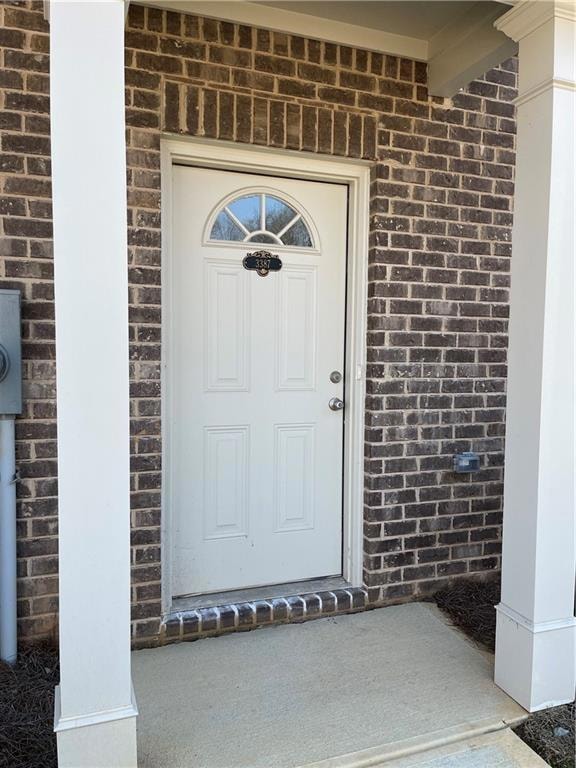 Doorway to property with brick siding