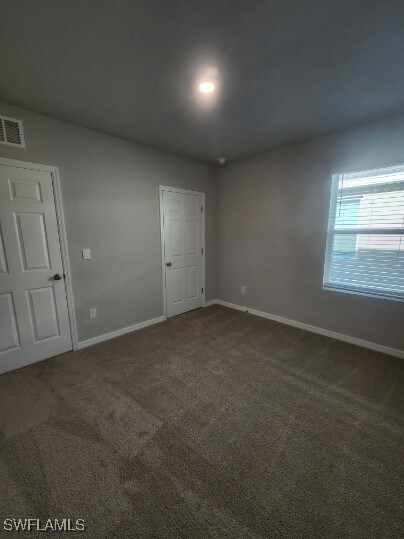 Unfurnished room featuring carpet floors, baseboar