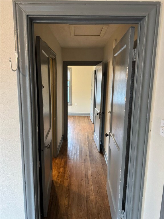Hall with dark hardwood / wood-style floors