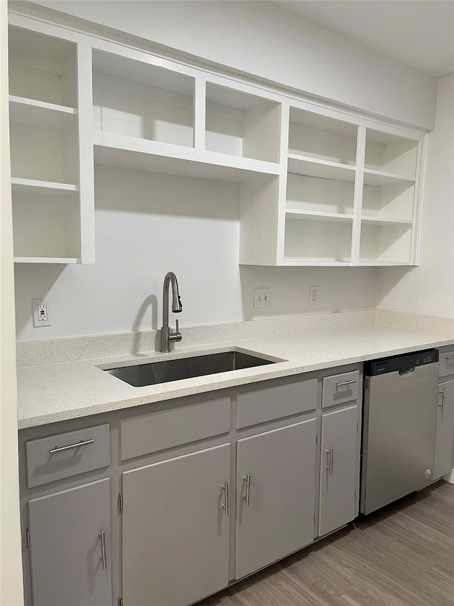 Kitchen featuring dishwasher, open shelves, a sin