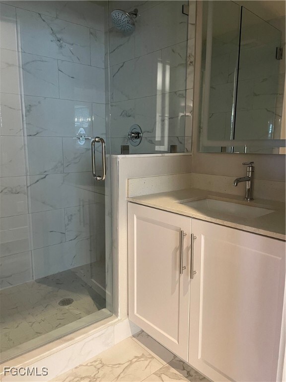 1st floor Bathroom with light marble finish flooring, vanity, and a marble finish shower