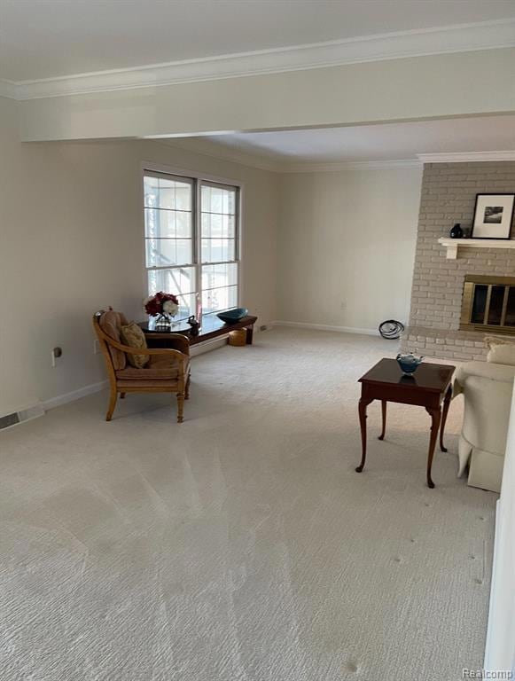Living area with crown molding, light colored carpet, and a fireplace