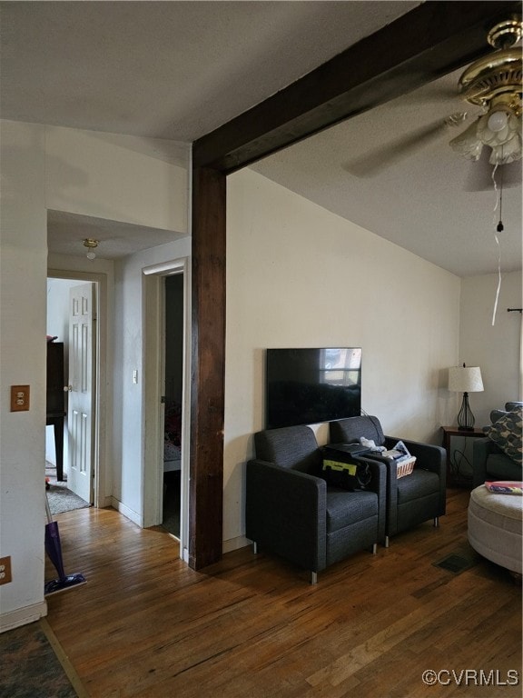 Living room featuring ceiling fan, beamed ceiling,