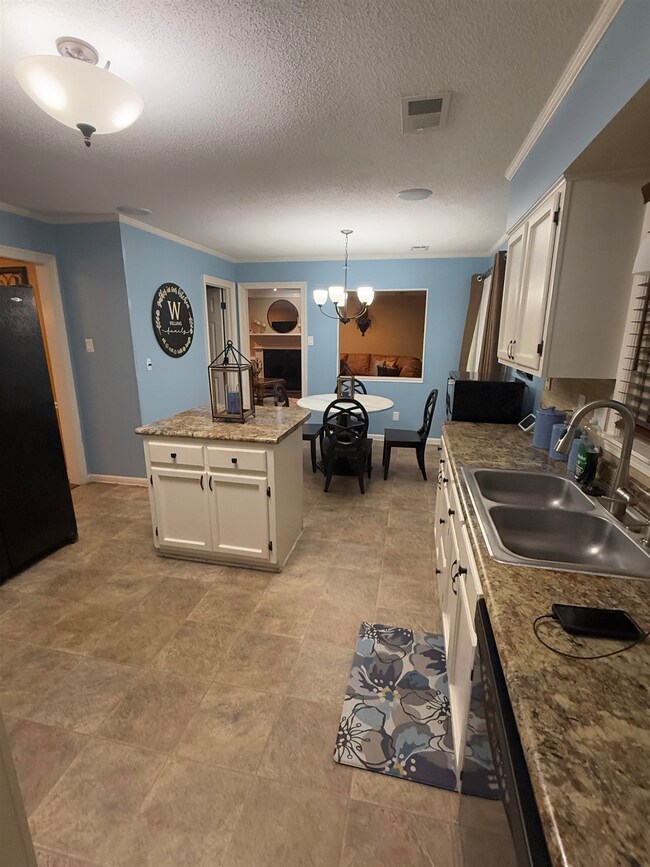 Kitchen featuring a sink, white cabinetry, hanging