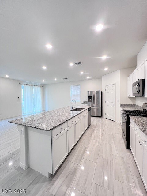 Kitchen featuring sink, stove, fridge, white cabin