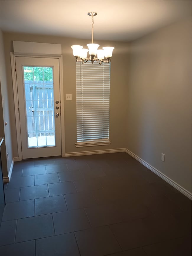 Doorway with a chandelier and tile patterned floors