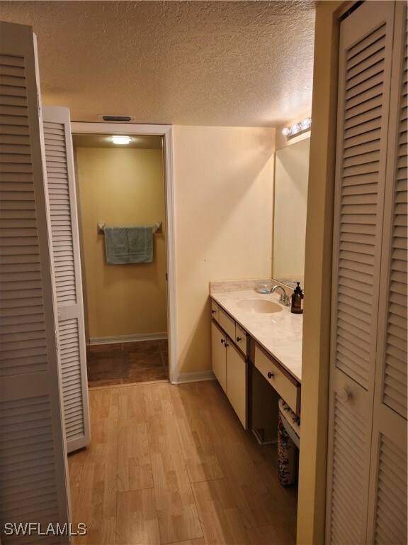 Bathroom featuring a textured ceiling, vanity, and