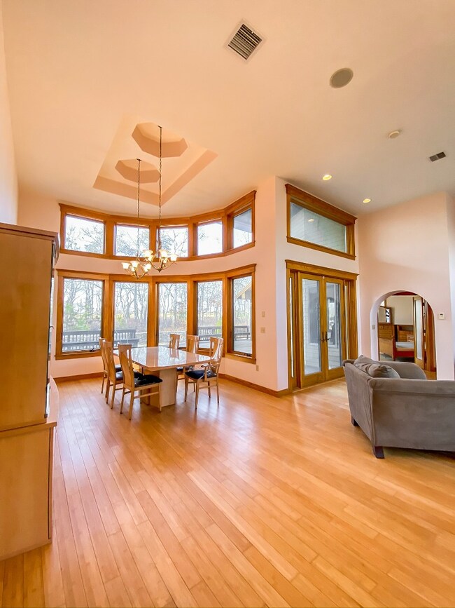 Looking at dining area from front entryway. Double glass doors to the right open to the back deck