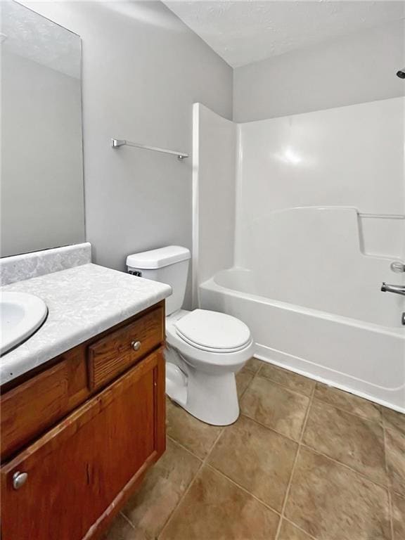 Full bath featuring toilet, vanity, tile patterned