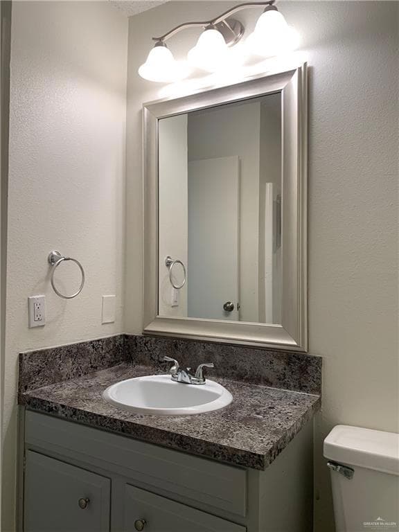 Bathroom with a textured wall and vanity