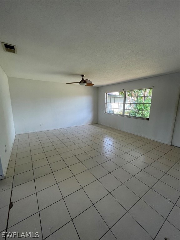 Spare room with ceiling fan, a textured ceiling, a