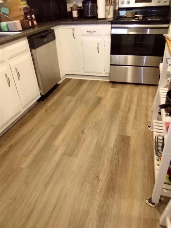 Kitchen with light wood finished floors, appliance