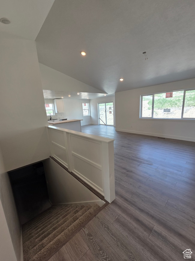 Kitchen featuring a peninsula, dark wood-style floors, recessed lighting, open floor plan, and white cabinets