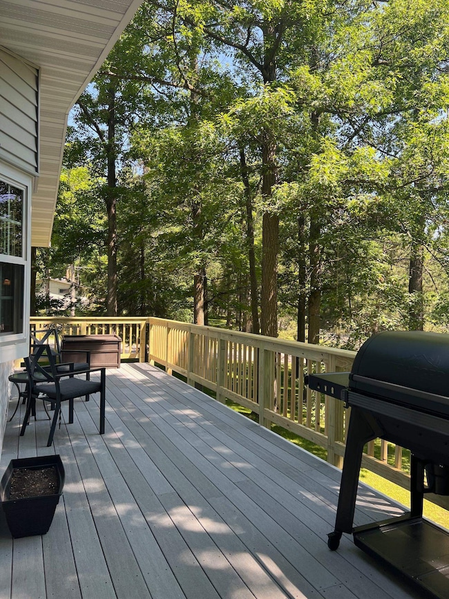 Wooden deck featuring a grill and view of wooded area