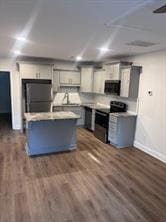 Kitchen with fridge, baseboards, gray cabinetry, and dark wood finished floors
