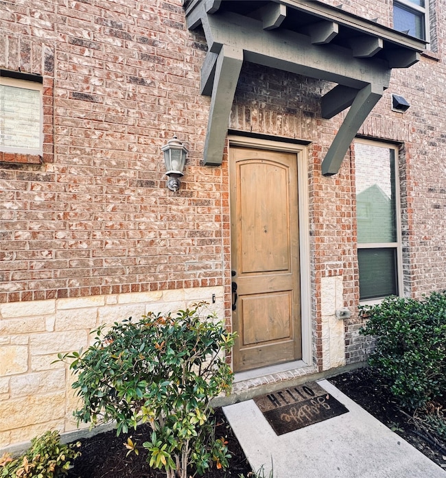 Entrance to property featuring brick siding