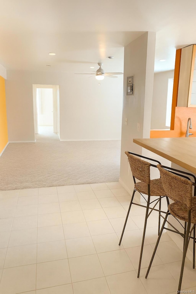 Entry/ foyer, featuring natural light and a ceiling fan in the living room. AI enhanced.