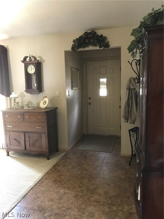 FOYER ENTRANCE WITH ARMSTRONG ALTERNA TILE FLOORING THAT FLOWS INTO THE KITCHEN