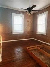 Empty room featuring dark wood-type flooring and ceiling fan