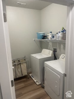 Laundry room featuring dark wood-style flooring and separate washer and dryer