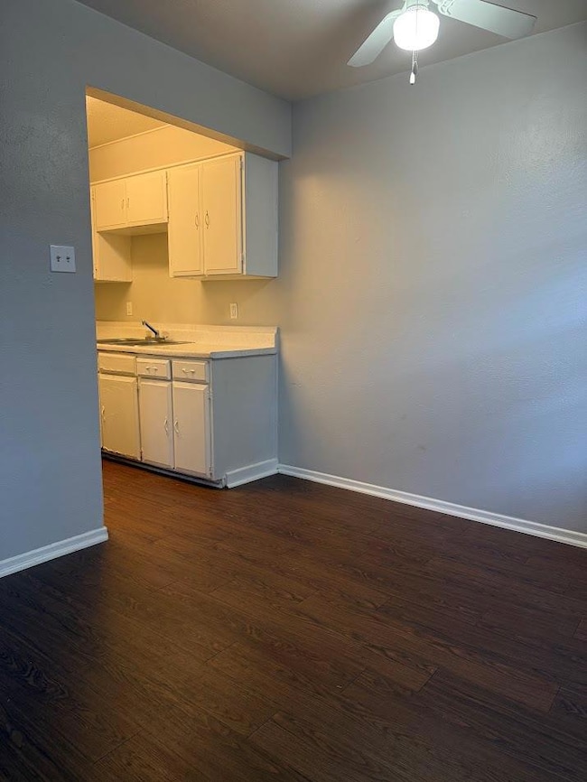 Kitchen with baseboards, dark wood-style floors, 