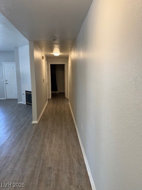 Corridor with dark wood finished floors and a text
