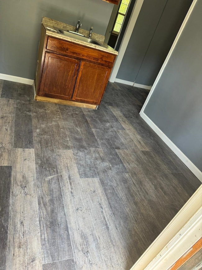 Bathroom with wood finished floors, vanity, and baseboards