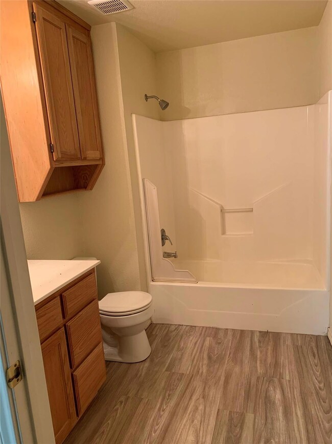 Full bathroom with wood-type flooring, shower / tu
