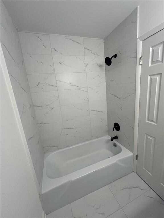 Bathroom featuring marble finish floors and  shower combination