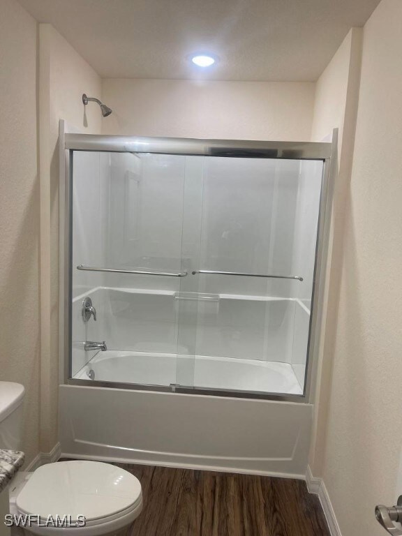 Full bathroom with toilet, wood finished floors, e