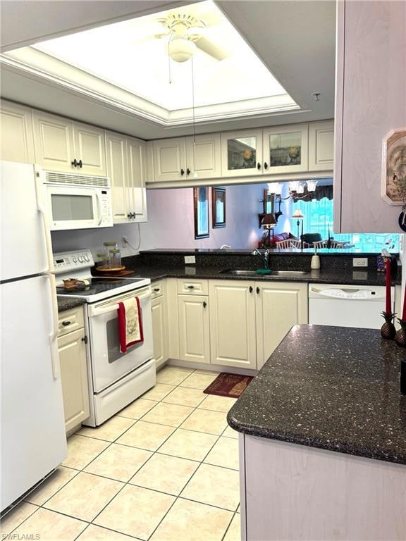 Kitchen featuring white appliances, white cabinetr
