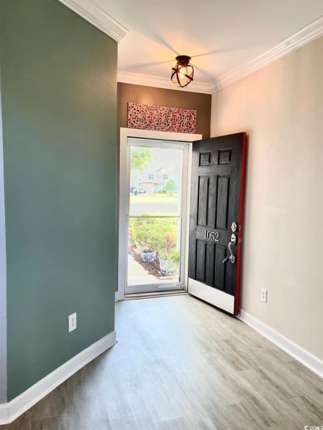 Foyer featuring wood finished floors, baseboards, 