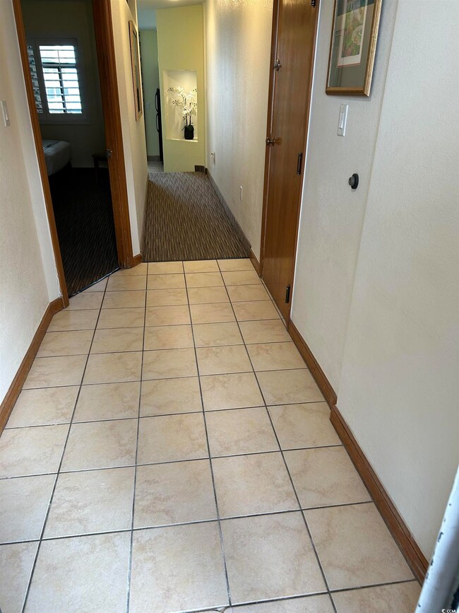 Hallway featuring light tile patterned floors