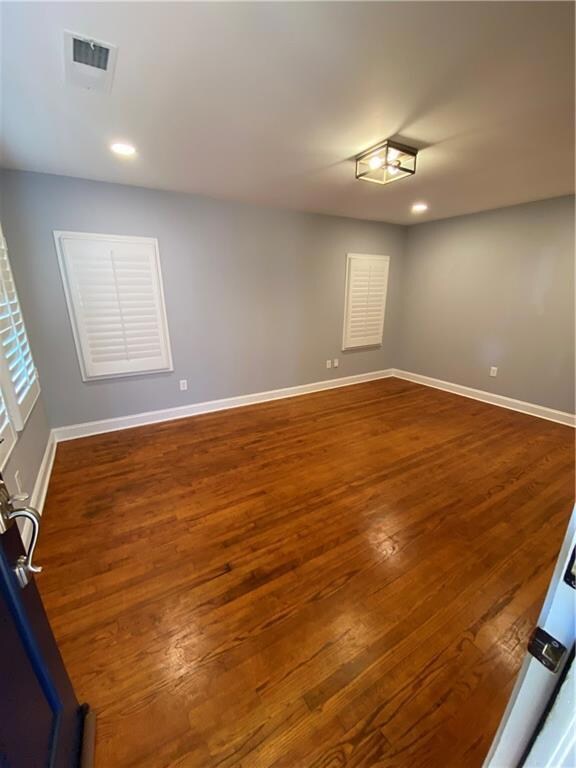 Empty room with wood finished floors, baseboards, and recessed lighting
